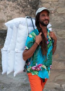 Hombre feliz con cojines y colchones artesanos.
